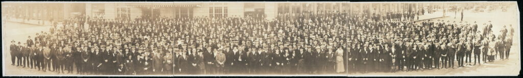 A panoramic photo of the 1919 35th annual convention of the Trades and Labour Congress of Canada. The photo shows many people standing in front of a building.